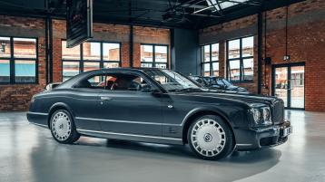 Side angled view of Bentley Brooklands Coupe featuring vented brakes and and Bentley Radiator Mascot, parked indoors.