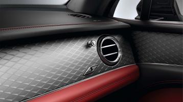 Interior passenger side view of Bentley Bentayga S, featuring Dark Tint Diamond Brushed Aluminium Fascia with S Overlays below Chrome metal bulls-eye air vents.  