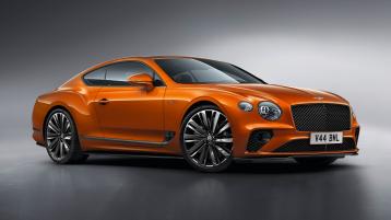 Front side angled view of Bentley Continental GT Speed in Orange Flame featuring 22" Speed Wheel -Dark Tint and wing vent with ‘12’ in the black ribbed matrix.