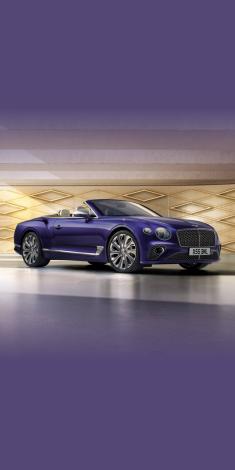 Front side angled view of Bentley Continental GTC Mulliner W12 in Tanzanite Purple colour, featuring 22 inch Mulliner Wheel Painted and Mulliner double diamond radiator grille - Black.