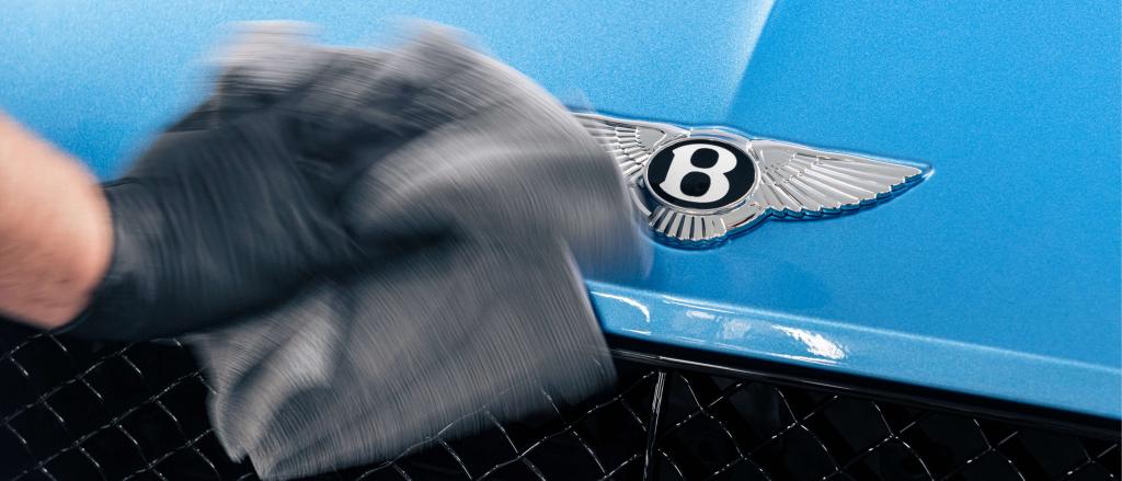 An electric angle polisher being used on Chrome Bentley wing badge to bonnet.
