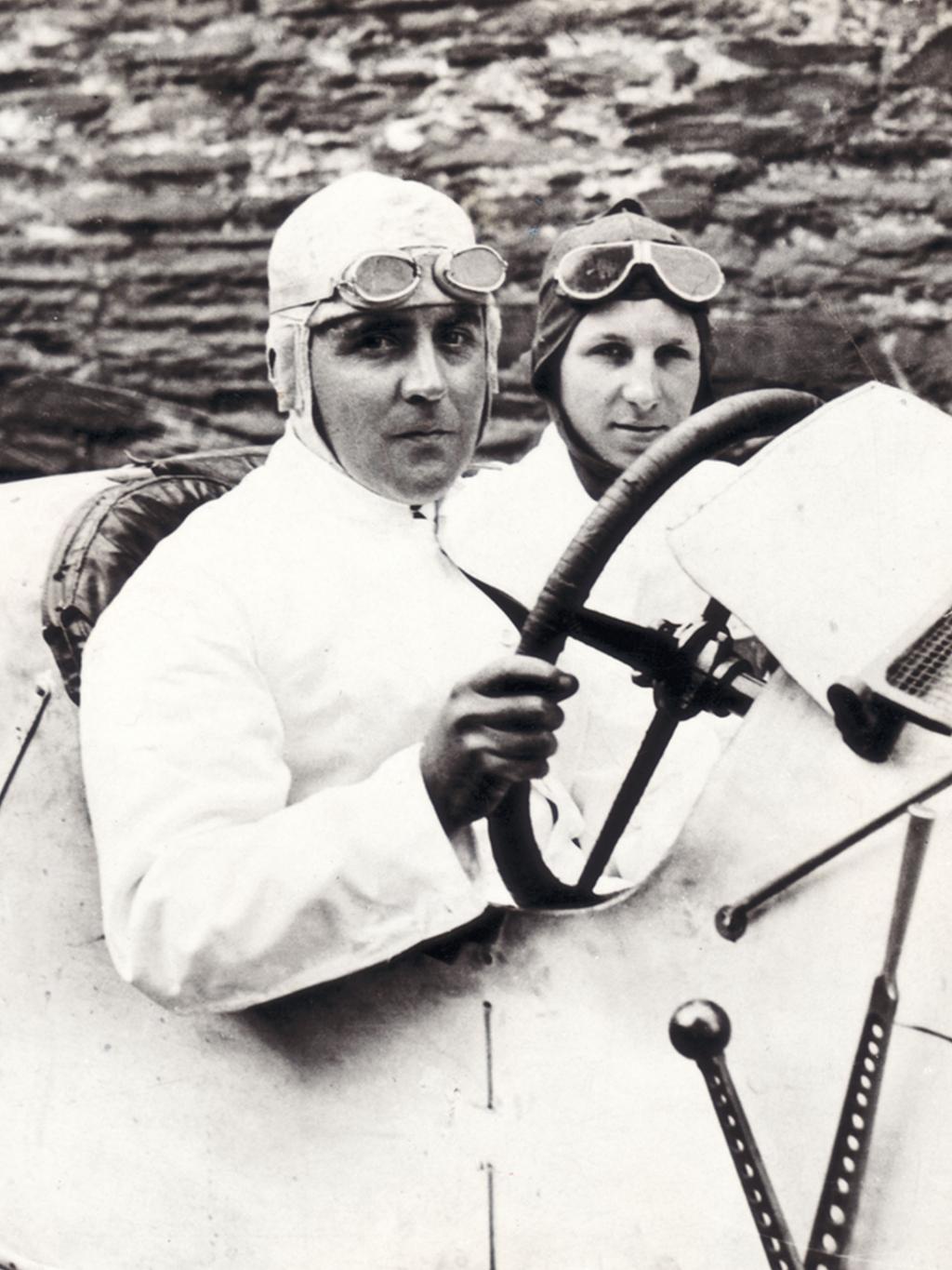 Man wearing sunglasses driving a Verdant green Bentley Blower.