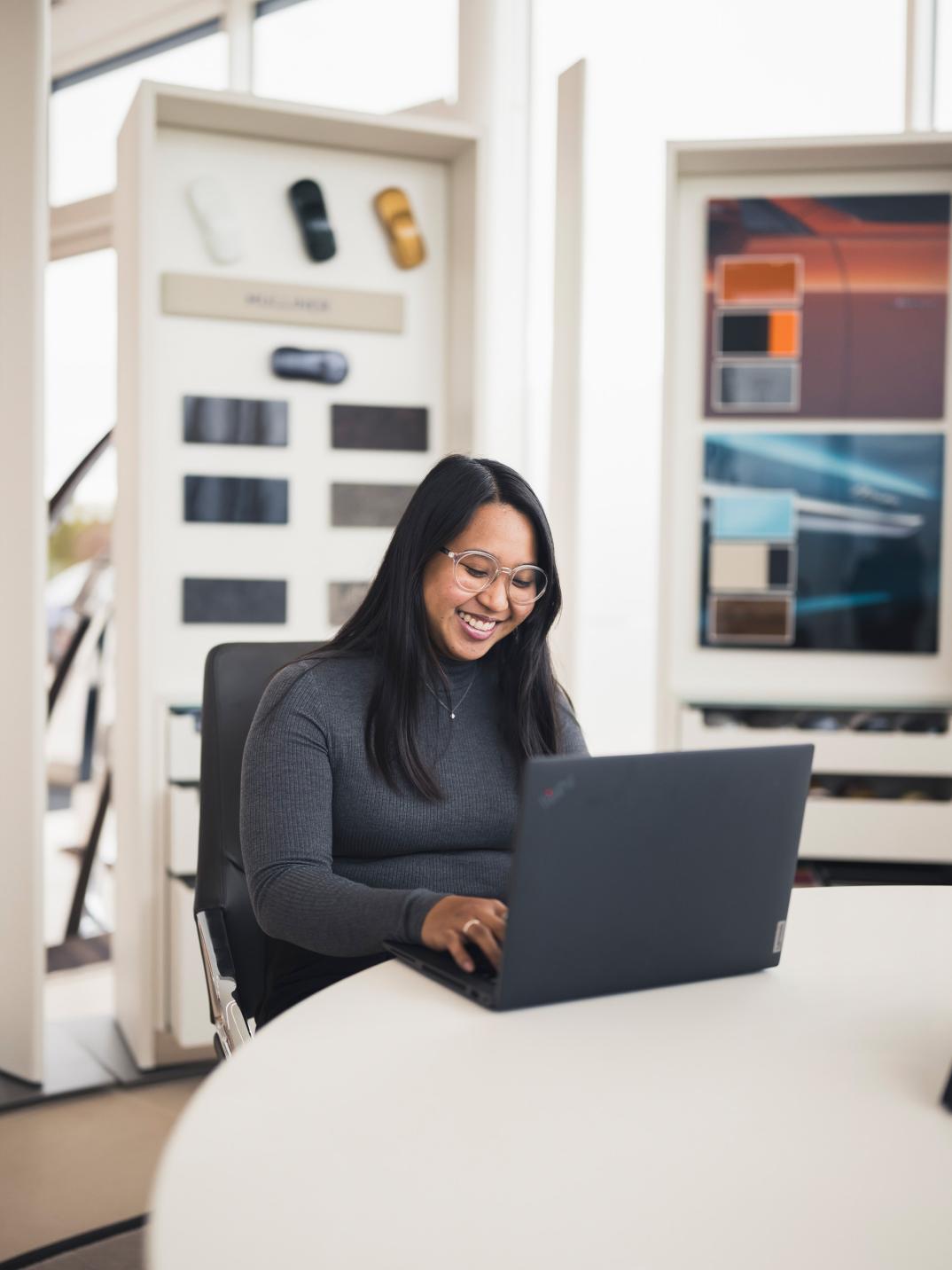 Yelena sat at a desk, typing on a laptop.