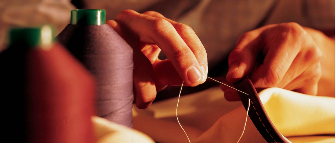 Close up of hands, sewing a Hotspur hide in Bentley Dream Factory, Crewe