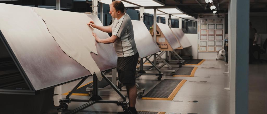 Bentley fabrication technician marking Linen Hide for cutting.