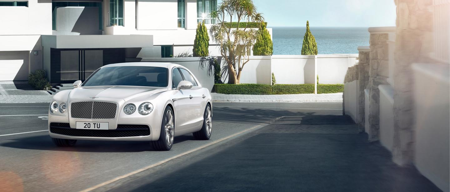 A 2018 Bentley Flying Spur driving in an urban environment