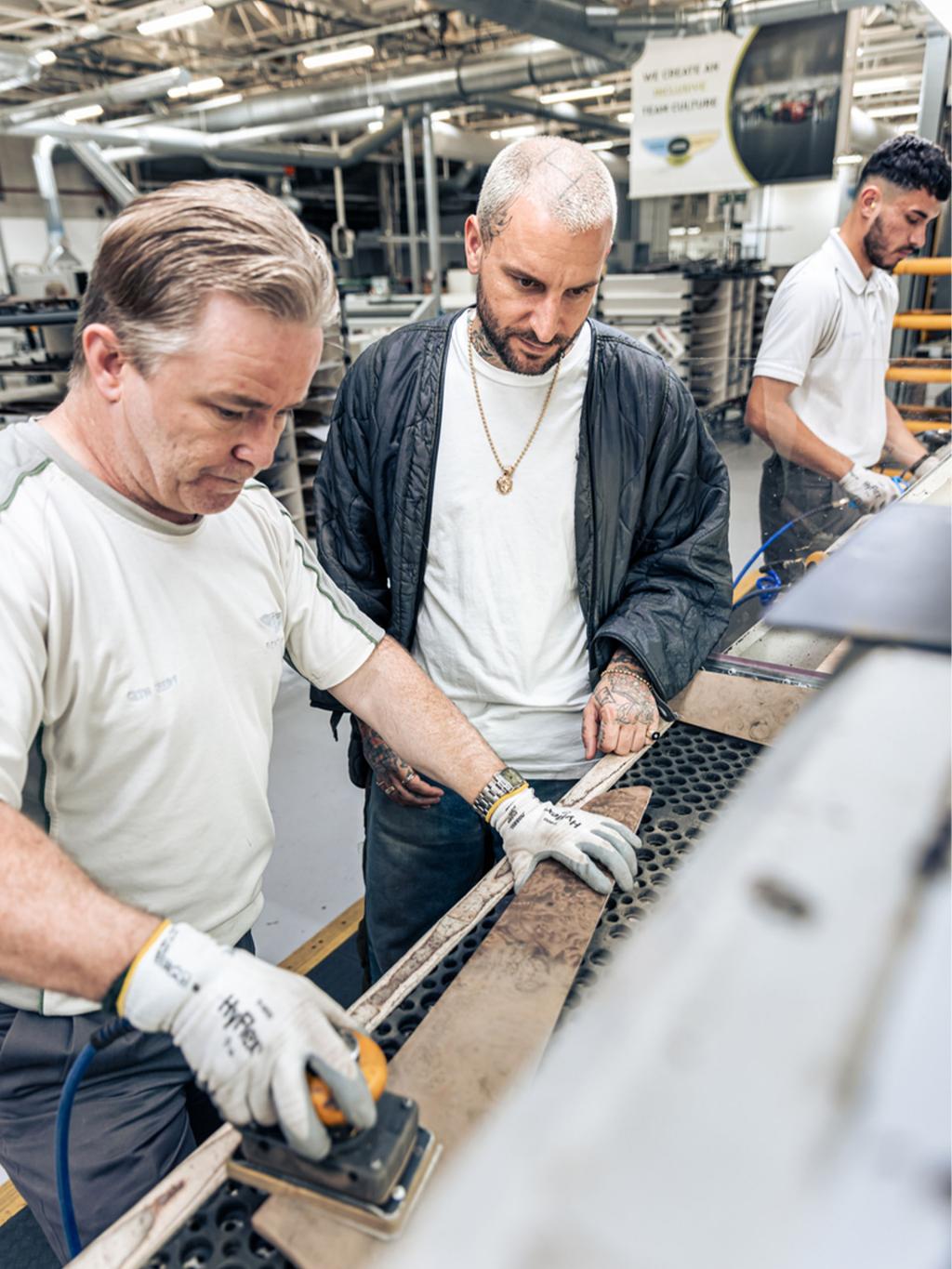 Bentley craftsman creating finishing for Bark Stained Burr Walnut veneer with another person looking over.
