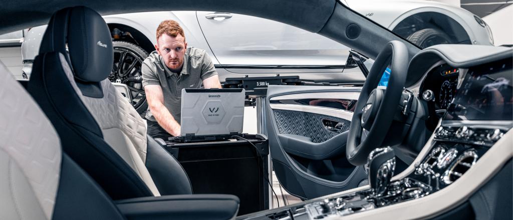 A technician with laptop running on board diagnostic test for Bentley Continental GT Azure