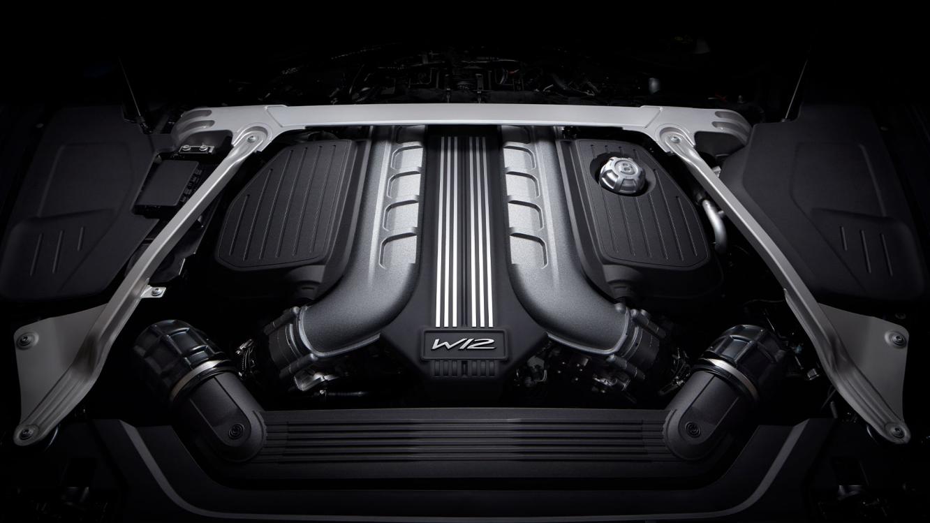 View of Bentley's W12 6.0 litre twin turbocharged engine installed in vehicle, Bentley Flying Wings Badge in view.