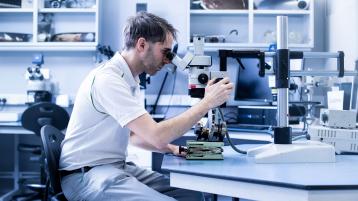 A Bentley technician working on compound microscope.