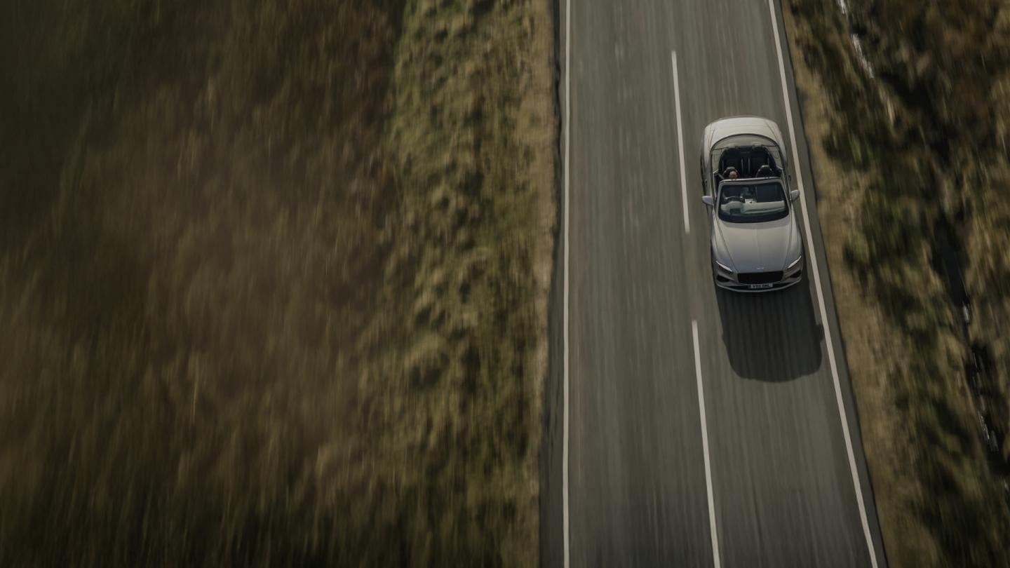 Aerial view of a new hybrid Continental GTC Speed driving in a rural environment