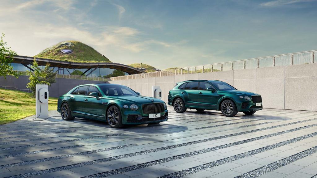 Bentley Flying Spur Hybrid and Bentley Bentayga Hybrid in Verdant Green colour, being recharged by Bentley branded PHEV charger in a private drive.