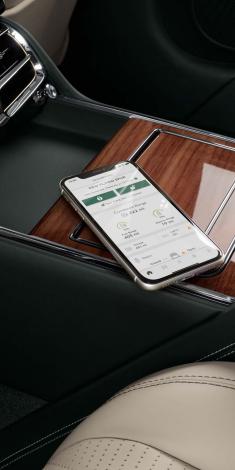 A smart phone placed in centre console, featuring My Bentley app configured for the New Flying Spur.