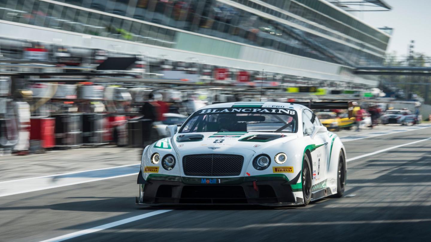 A first generation Bentley Continental GT3 race car driving down the Silverstone pits