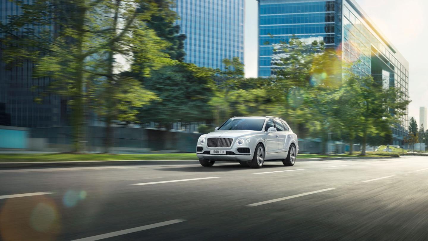Bentleys first hybrid, the first generation Bentayga Hybrid driving in an urban metropolis