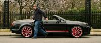 Chart Chirthivat exiting his Bentley Supersports ISR, which is parked at the side of the road.