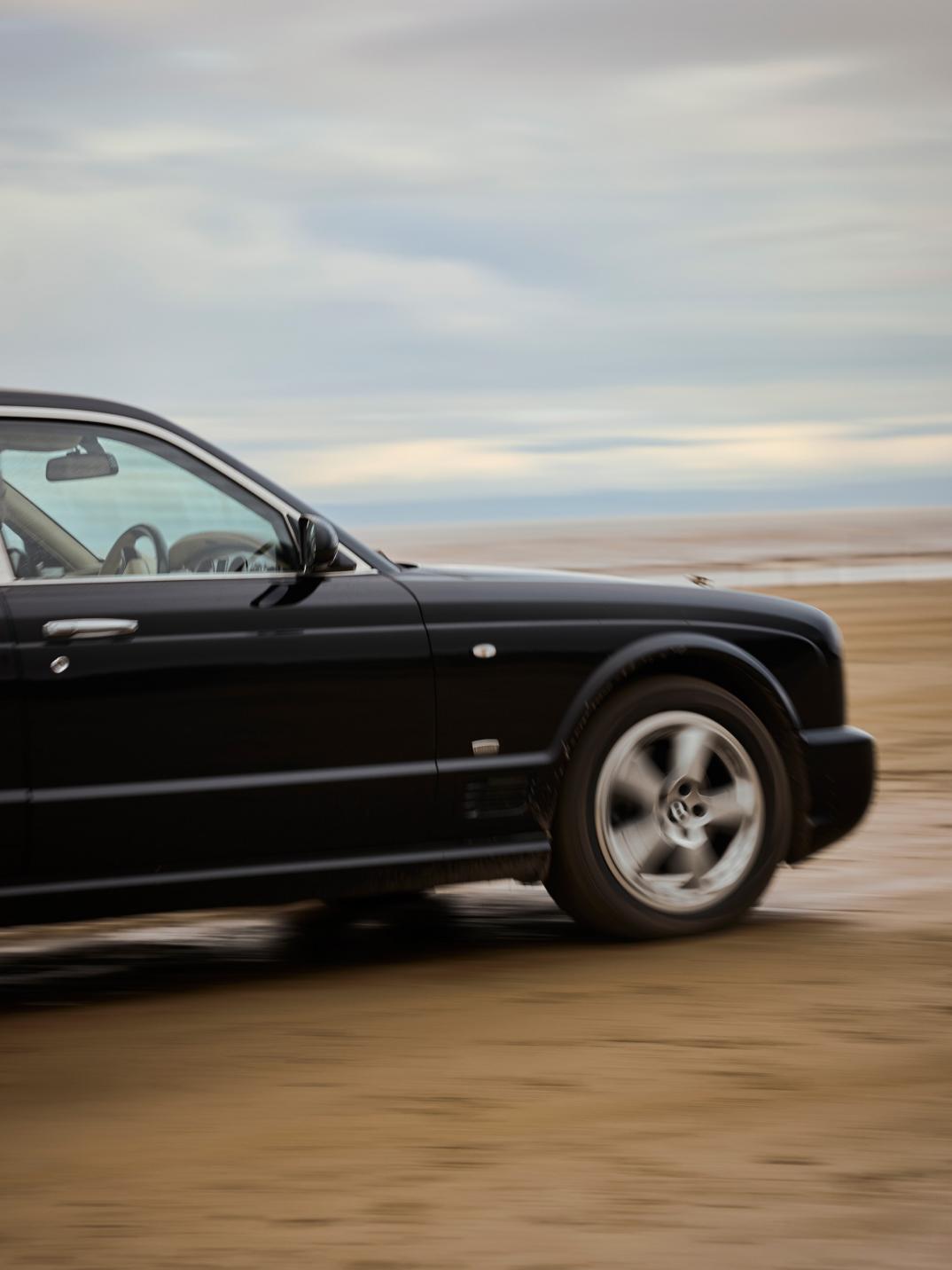 Front side of Hubert de Pelet's Bentley Arnage T, driving across sand.