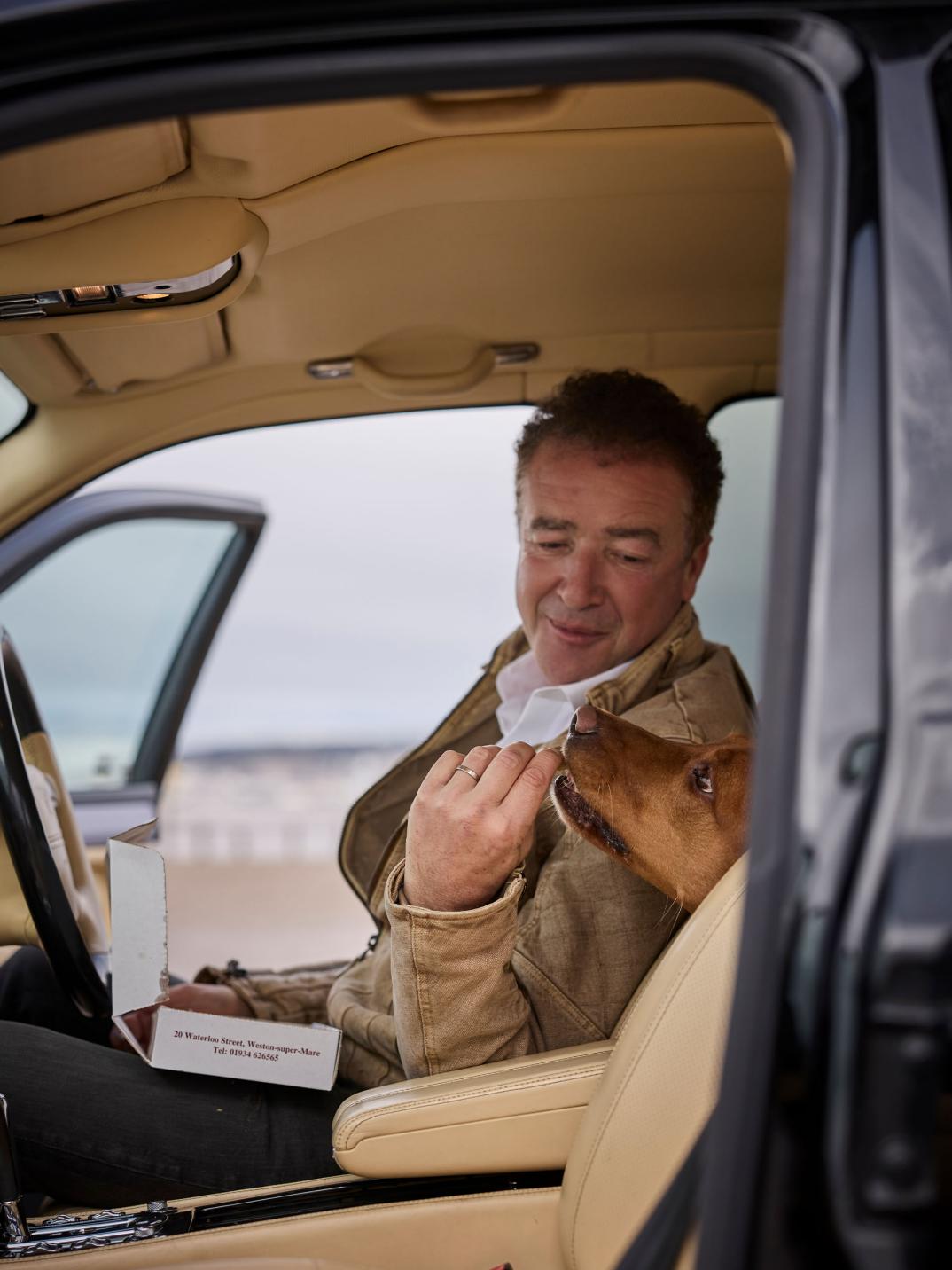Hubert de Pelet feeding his dog while sat in his Bentley Arnage T.