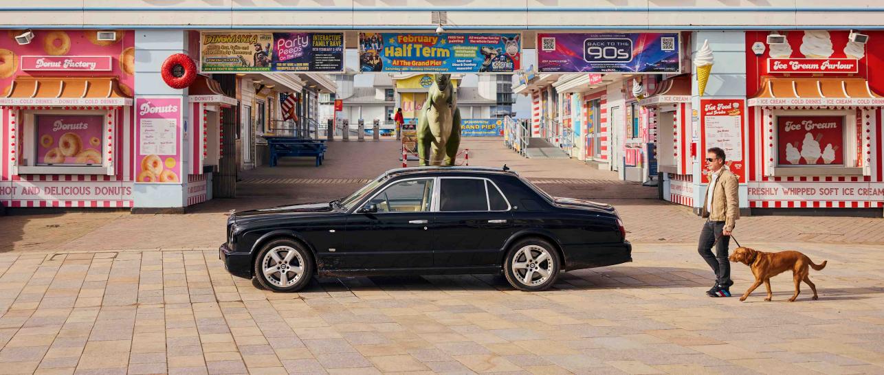 Hubert de Pelet walking with his dog towards his Bentley Arnage T on a pier.