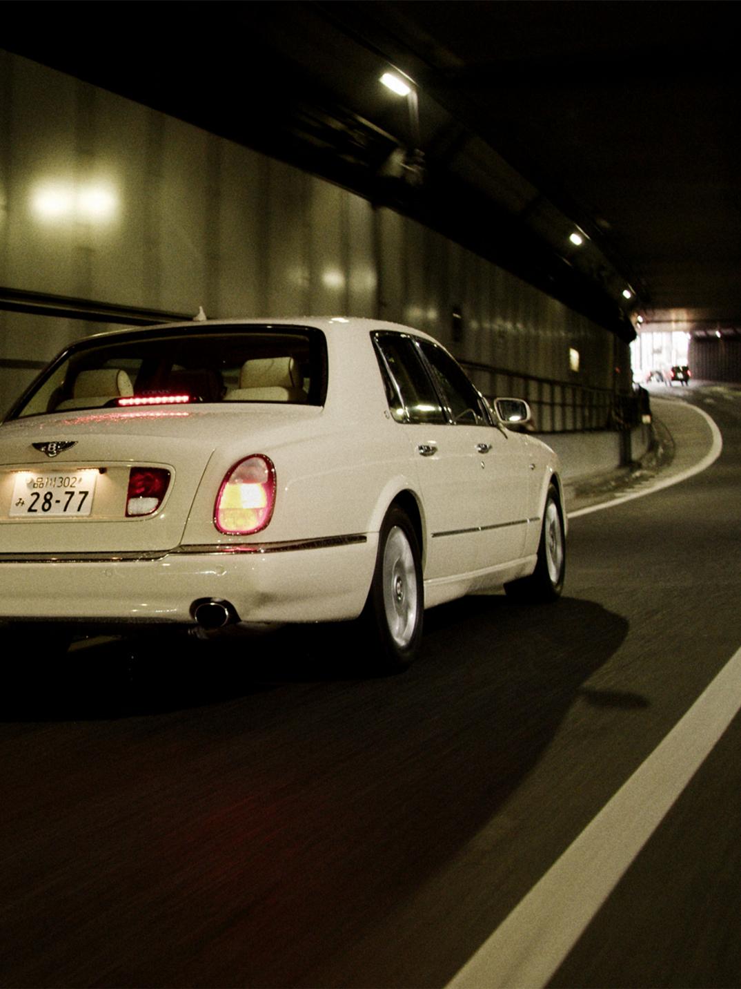 Kota driving his Bentley Arnage through a tunnel.