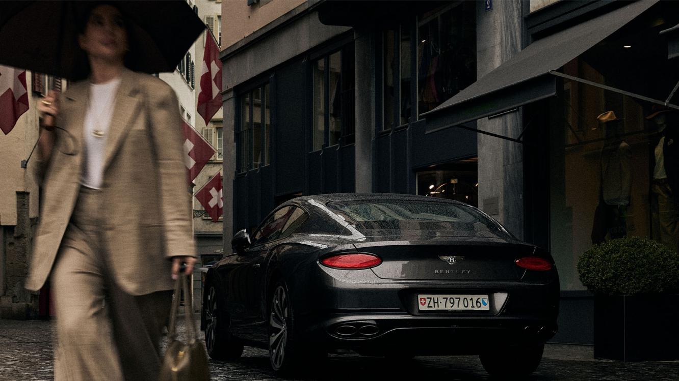 Leyla Hajrovic walking away from her Bentley Continental GT.