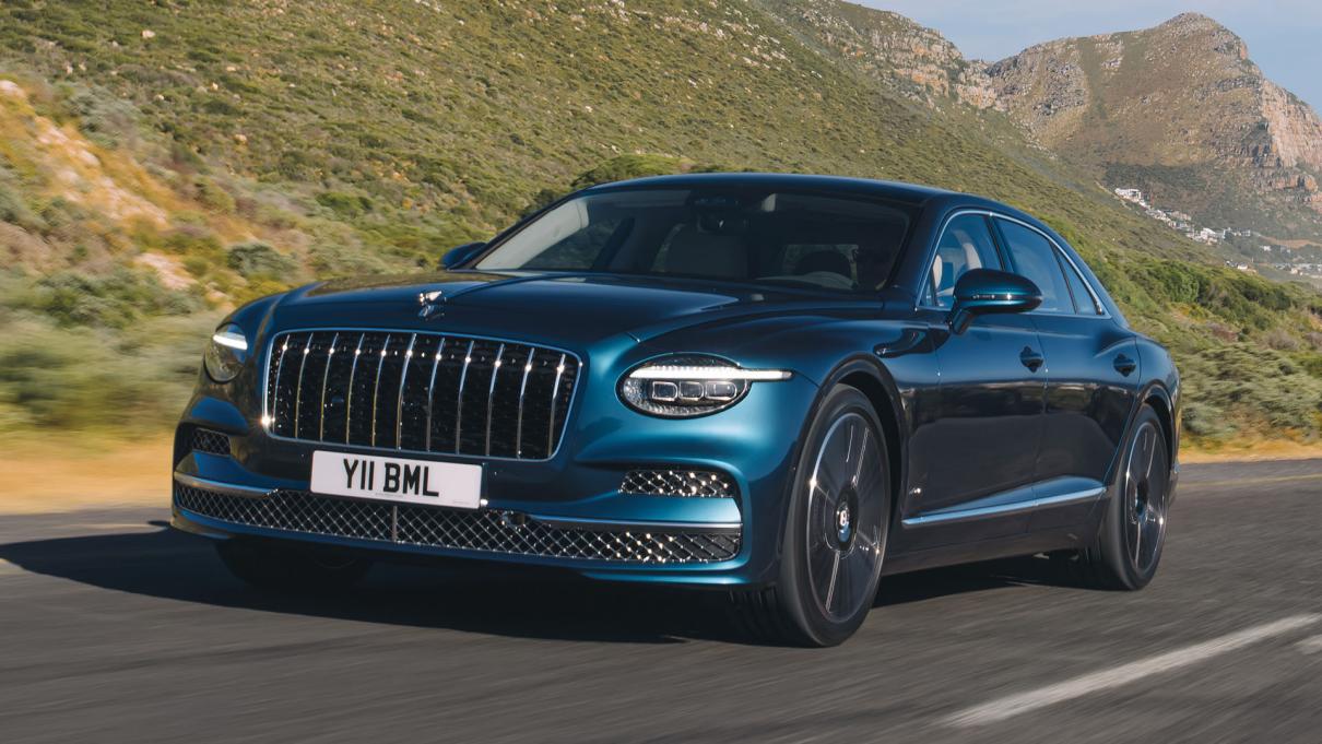 Bentley Flying Spur Azure driving with mountains in the background.