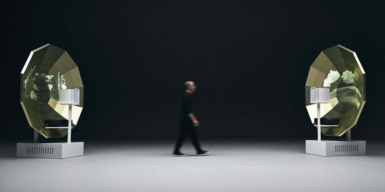 T. Jon walking between parabolic speakers.