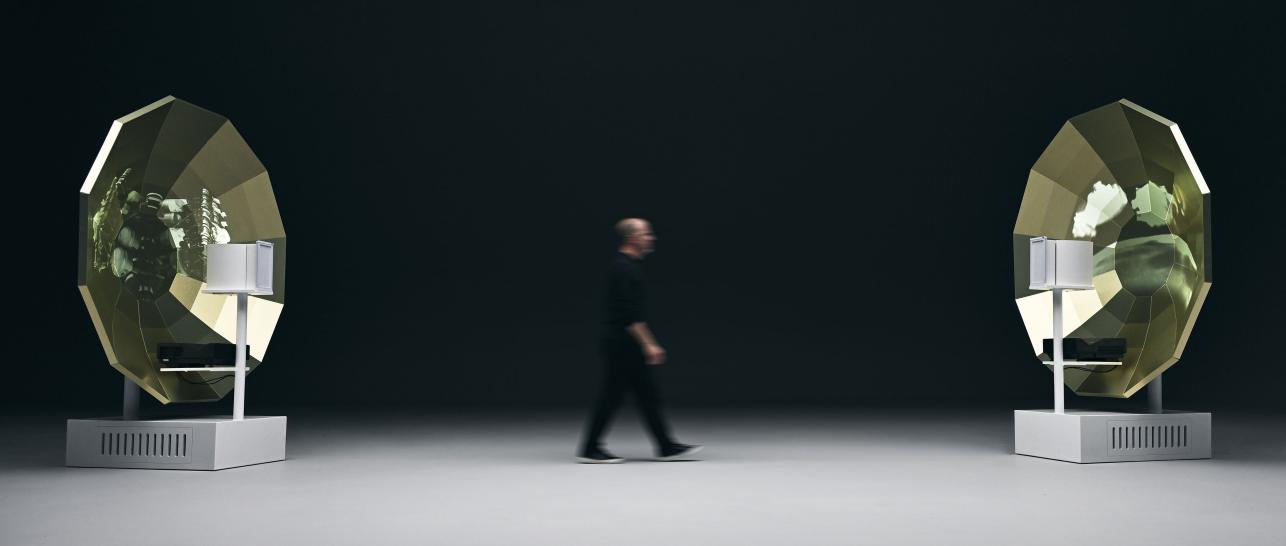 T. Jon walking between parabolic speakers.