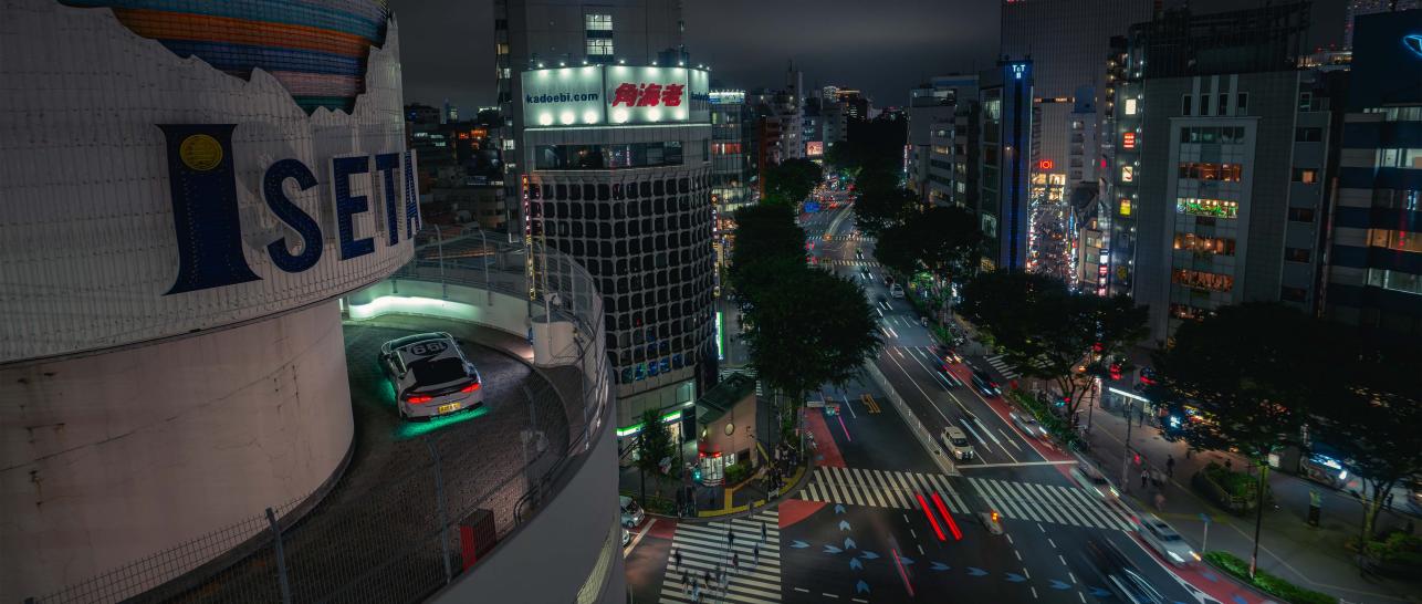 Bentley Supersports driving with Tokyo streets in the background.