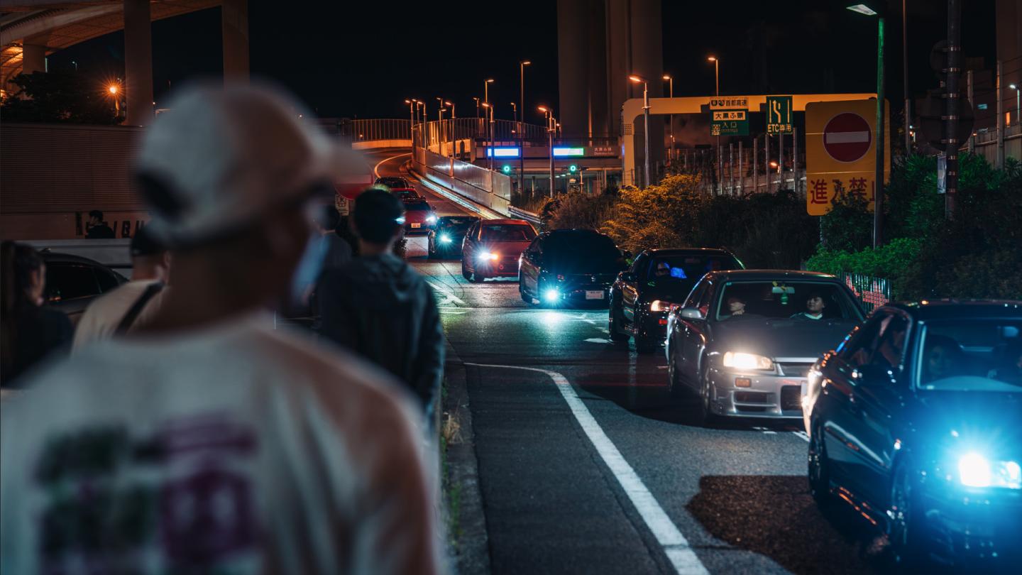Line of cars driving down a road.