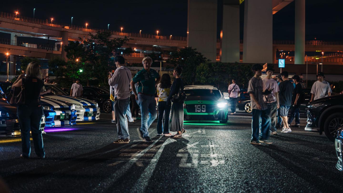 Bentley Supersports behind crowds of people.
