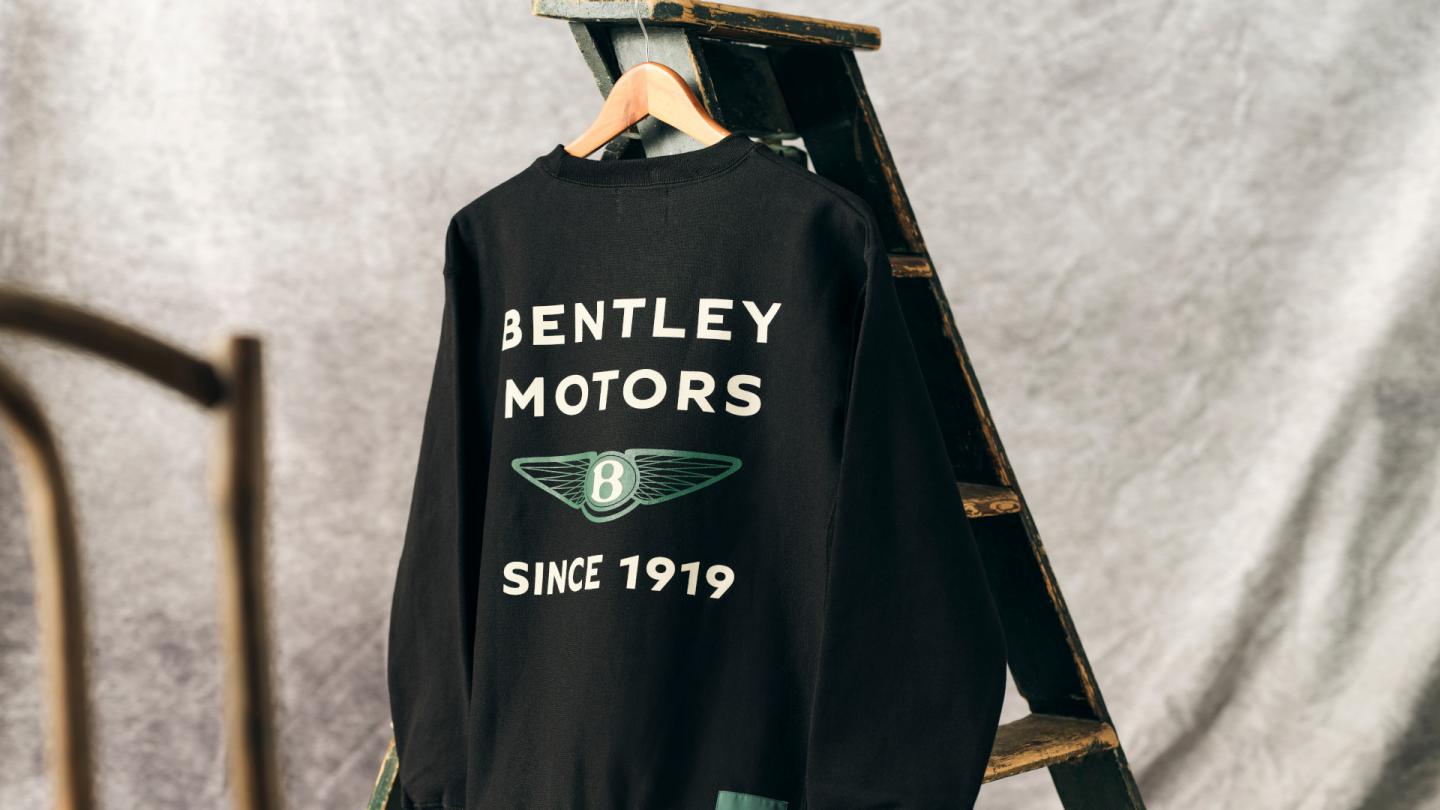 The black jumper available in the 1919 Collection with white embroidery and the Bentley wings in Bentley green