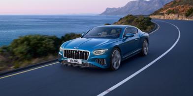 Front side angled view of Continental GT Azure in Light Windsor Blue driving by the sea