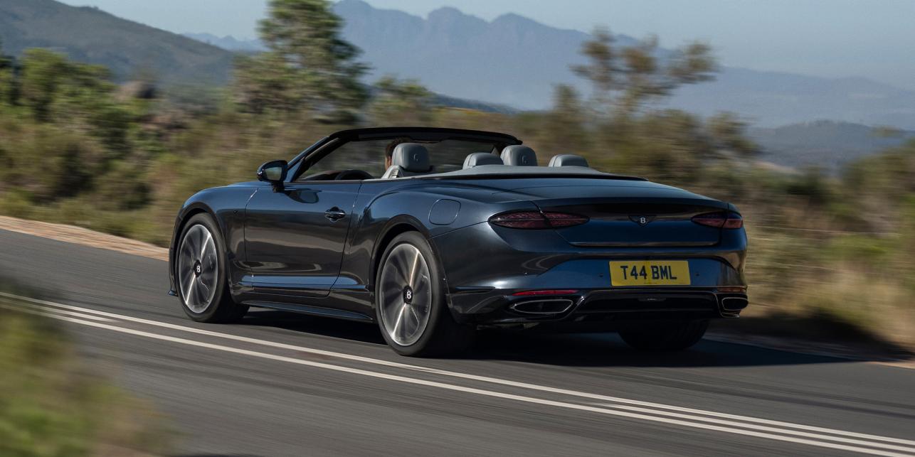 The new Hybrid Bentley Continental GTC S in Thunder Grey driving dynamically in a rural environment