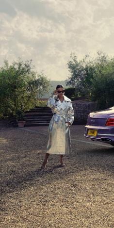 A model posing behind a Bentley Flying Spur Mulliner in Tanzanite purple colour.