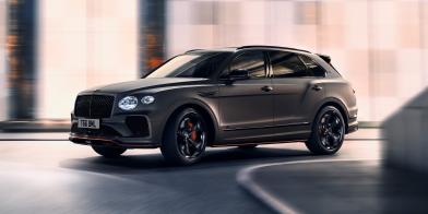 Bentayga Black Edition, with satin paint driving dynamically on a city street. 