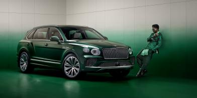 Wisdom Kaye standing next to the front three quarter of the Bentayga Atelier Edition in an Emerald exterior colours with bright chrome accents