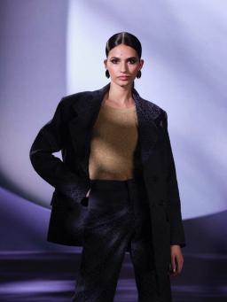 A female model wearing a gold dress and earings