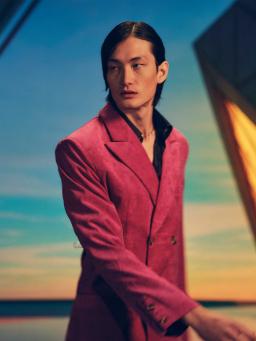Individual/man dressed in pink suit posing for a photograph