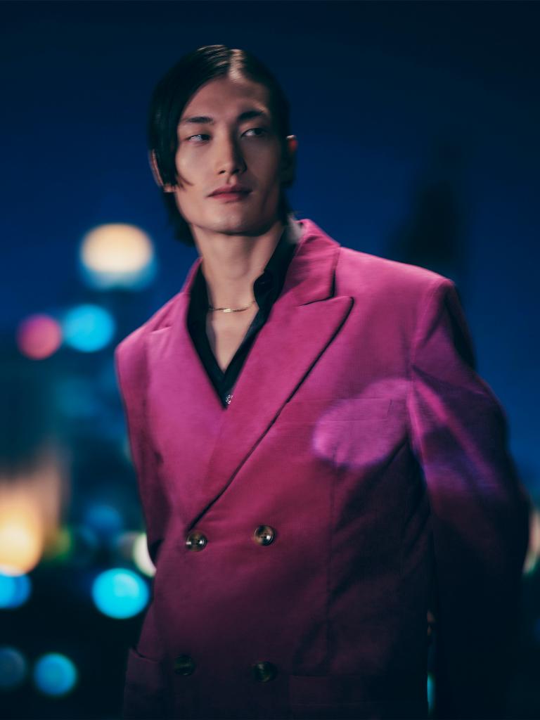 Individual/man dressed in pink suit posing for a photograph