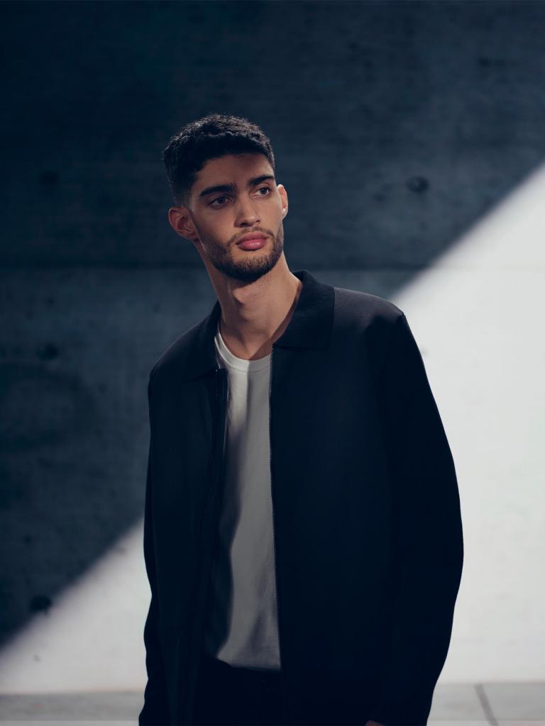 Individual/Man/Person dressed in dark navy blue jacket and turtle neck, posing for a picutre.