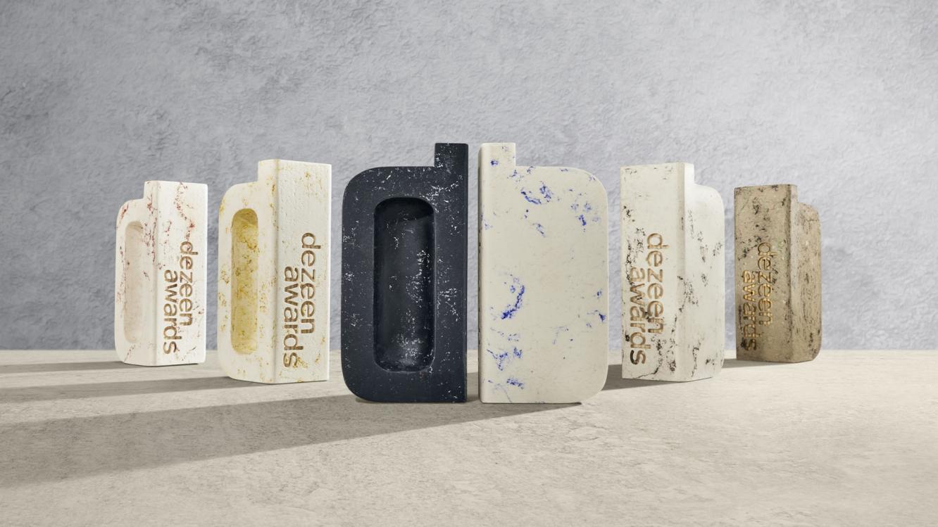 Dezeen Awards engraved bricks stood on a marble surface.