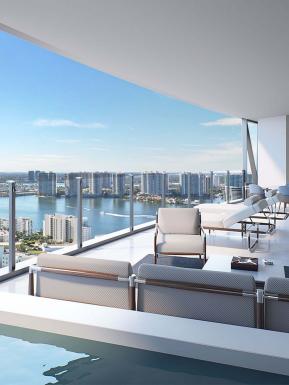 Bentley Residence Miami, with reclining chairs on terrace overlooking water bodies around Sunny Isles Beach.
