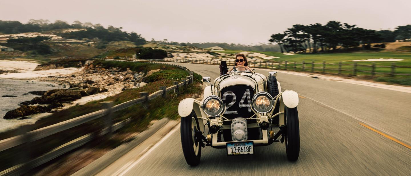 Side angled view of a white Blower Jnr customer car being driven in Monterey