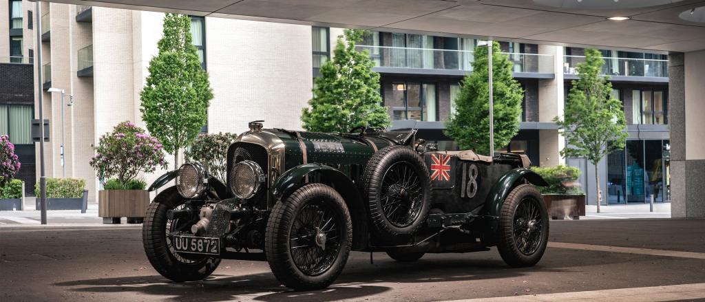 Side angled view of Bentley Blower Jnr in Verdant Green view, parked infront of high rise buildings.