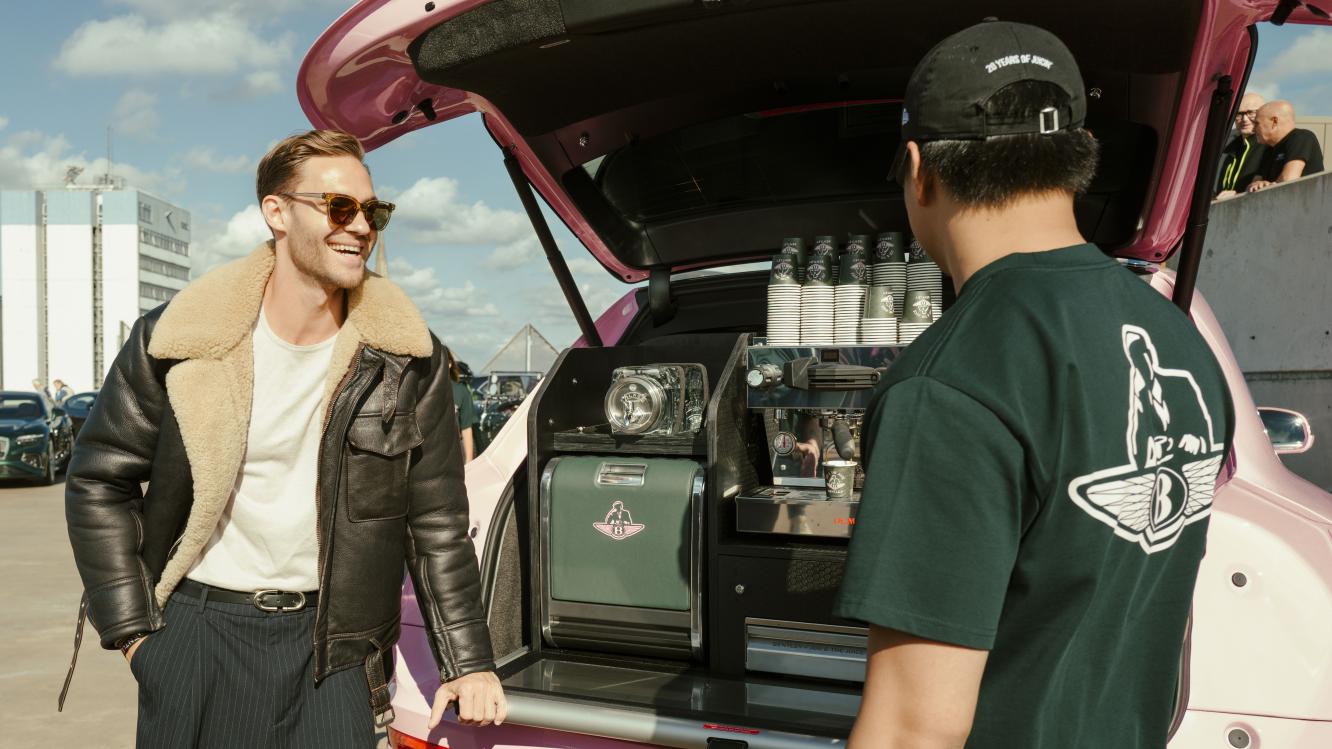 Espresso machine in the Bentley x Joe & The Juice Bentayga, with two people stood next to it.