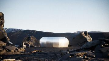 Futuristic architecture of enclosed metallic capsule  featured in Bentley Dezeen design competion in Iceland, with rocky mountains in backdrop.