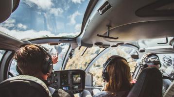 Participant of Bentley's Extra Ordinary Journey sightseeing in a helicopter with pilot guiding.