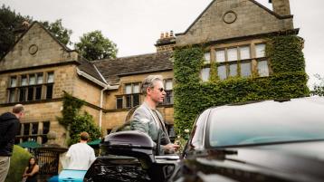 A person standing infront of Bentley Flying Spur