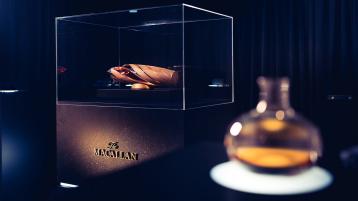 The iconic Macallan whiskey bottle reflecting Bentley's architectural design, placed in glass casing.